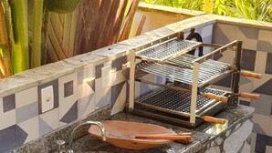 An outdoor kitchen with a built-in grill, a sink, and a cutting board. - Andorinhas (Niteroi)