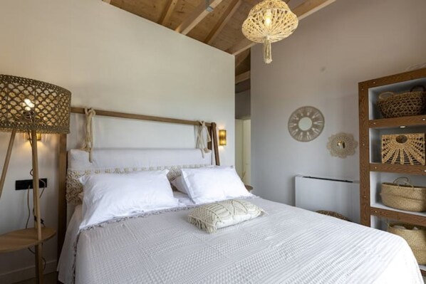 A bed with a wooden headboard, white bedding, and a woven lamp beside it. - Phos & Physis Luxury Villa (Kefalonia)
