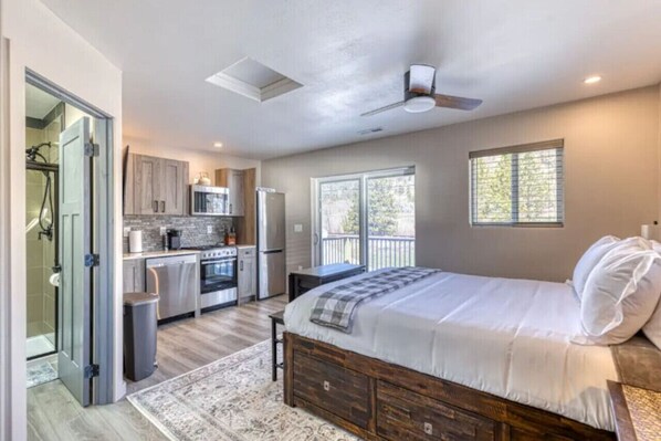 A bedroom with a large bed, a wooden headboard, and a nightstand. - Prickly Pear Studio Wolf Creek (Wolf Creek)