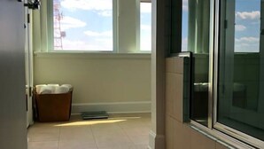 A hotel room with a large window, a sliding door, and a small rug on the floor. - 5-star Luxury Apartment - Atop the Seagle Building (Gainesville)