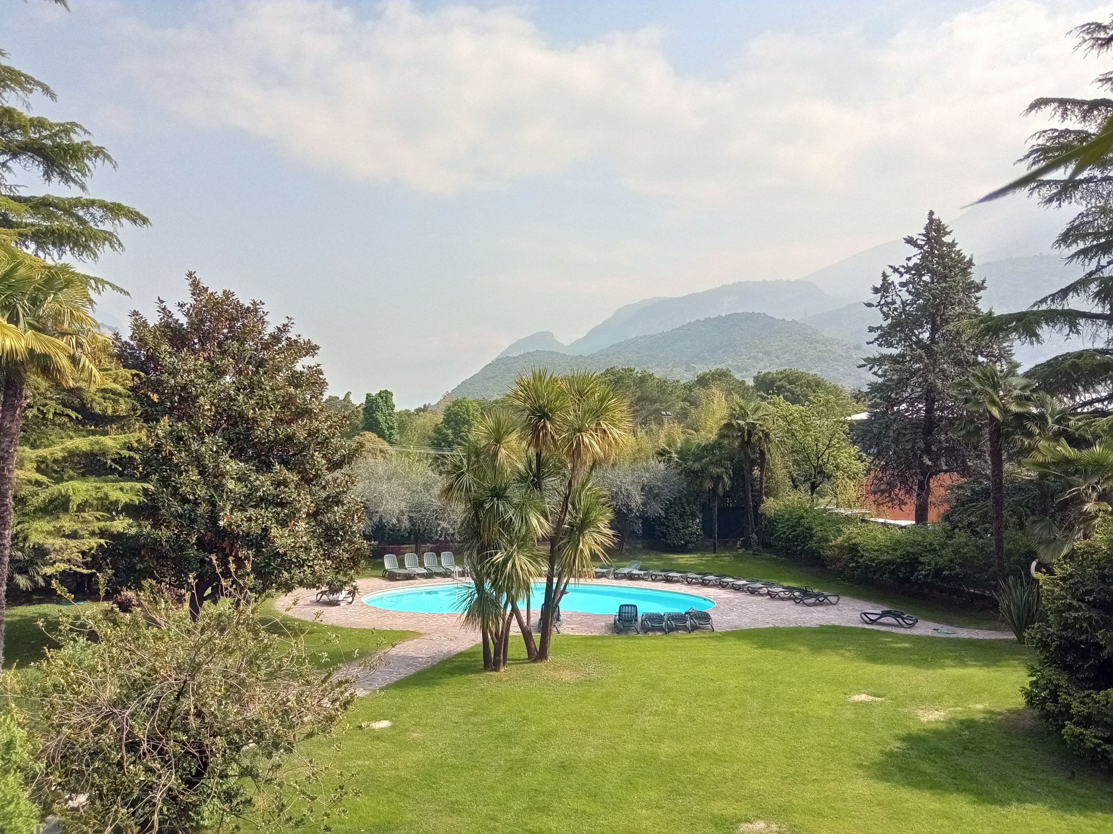 A pool surrounded by lush greenery and a mountainous backdrop.