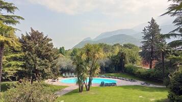 A pool surrounded by lush greenery and a mountainous backdrop.