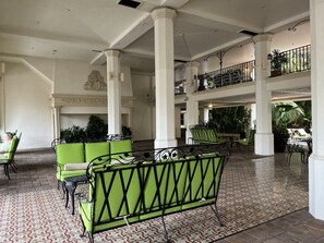 Eine geräumige Lobby mit hohen Decken, einer zentralen Säule und einem gemusterten Boden.