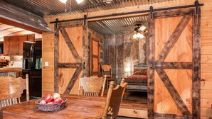 Un interior rústico de madera con una mesa de comedor, sillas y una cesta de manzanas.