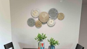 A dining area with a wooden table and four chairs. Above the table, there are decorative plates on the wall. - Charming 2 bed in Westminster (Westminster)