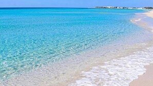 Uma praia com águas turquesa cristalinas e uma faixa de areia.