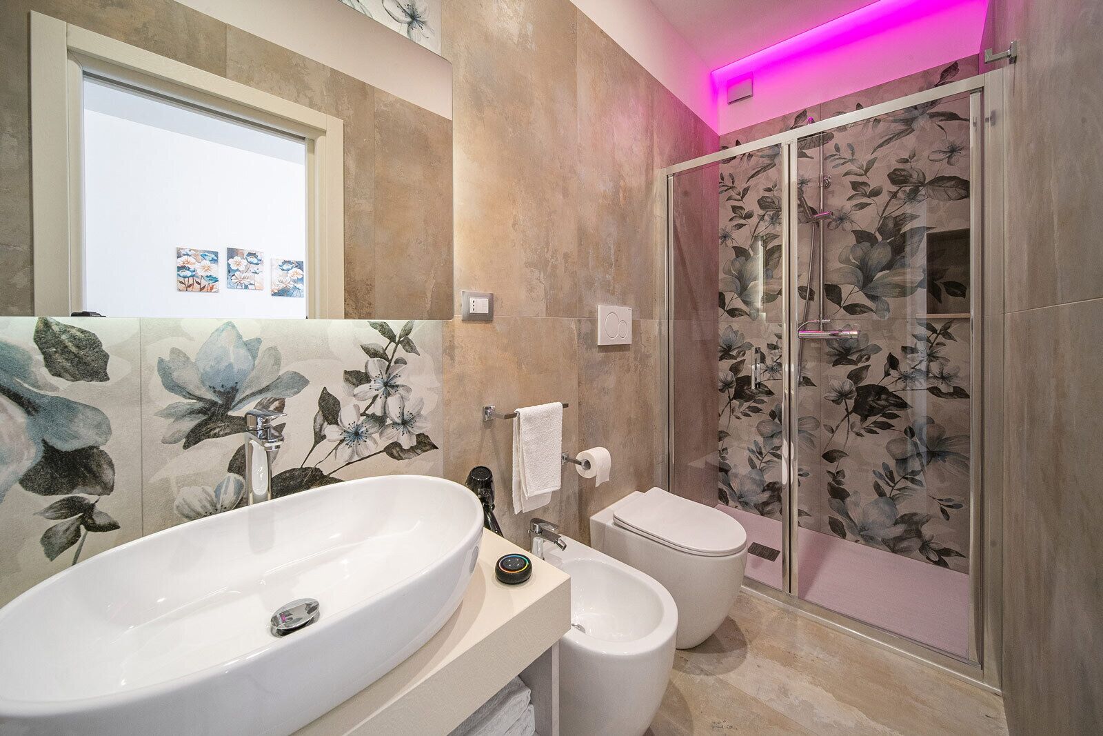 A bathroom with a large white sink, a toilet, and a glass-enclosed shower.
