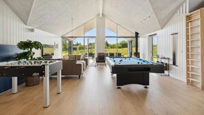 A spacious room with a foosball table, pool table, and a comfortable seating area with a view of the outdoors. - Gorgeous home in Rømø with sauna (Rømø)