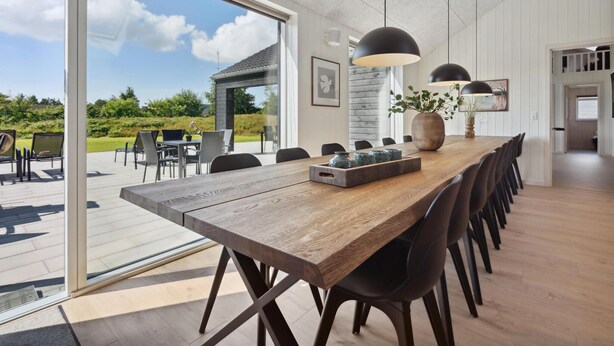 A spacious dining area with a long wooden table, black chairs, and pendant lights. - Gorgeous home in Rømø with sauna (Rømø)