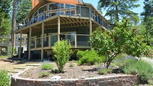 A multi-story building with balconies, surrounded by trees and a landscaped garden.