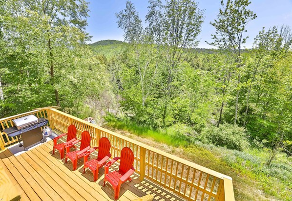A deck with a grill and red chairs overlooking a forested area. - Best Mountain Views Triple level Deck /w Hot tub facing mountains!! (Tannersville)