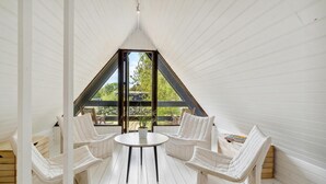 A white wooden interior with a central table and four white chairs.