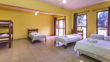 A room with two single beds, a bunk bed, and a ceiling fan.