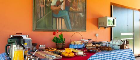 A breakfast buffet with various food items and a painting on the wall.