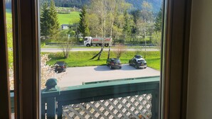 Vista dalla finestra su un'area di parcheggio con un camion e tre automobili.