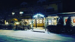 Un hotel con ingresso innevato e insegne illuminate.