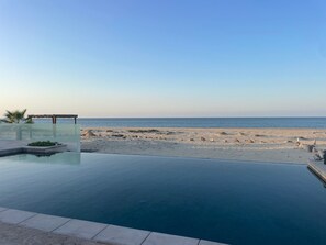 A clear view of a beach with a swimming pool in the foreground. - Beautiful Beach front Villa (La Ribera, Baja California Sur, Mexico)
