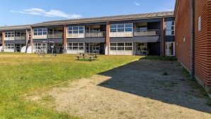 A multi-story building with a flat roof, large windows, and a brick facade. - Fanø Bad, værelse 21 (Fanø)