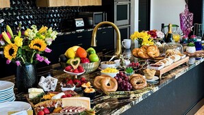 Um buffet de café da manhã com diversas opções de alimentos e bebidas.