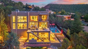 Uma casa moderna de vários andares com piscina, área de estar ao ar livre e um jardim bem cuidado.