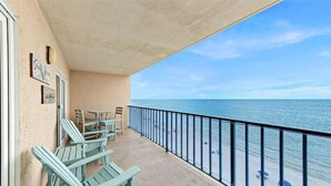 Un balcon avec des chaises et une table donnant sur l’océan.
