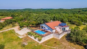 A house with a swimming pool, solar panels, and a view of a forested area. - Luxurious home in Rovinj (Rovinj)