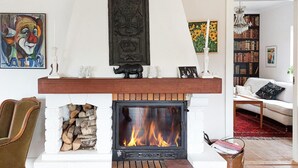 A fireplace with a mantel, a white brick surround, and a log storage area. - Awesome home in Genarp with WiFi (Genarp)