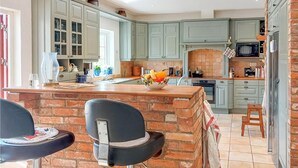 A kitchen with light green cabinets, a brick island, and a microwave. - Awesome home in Genarp with WiFi (Genarp)