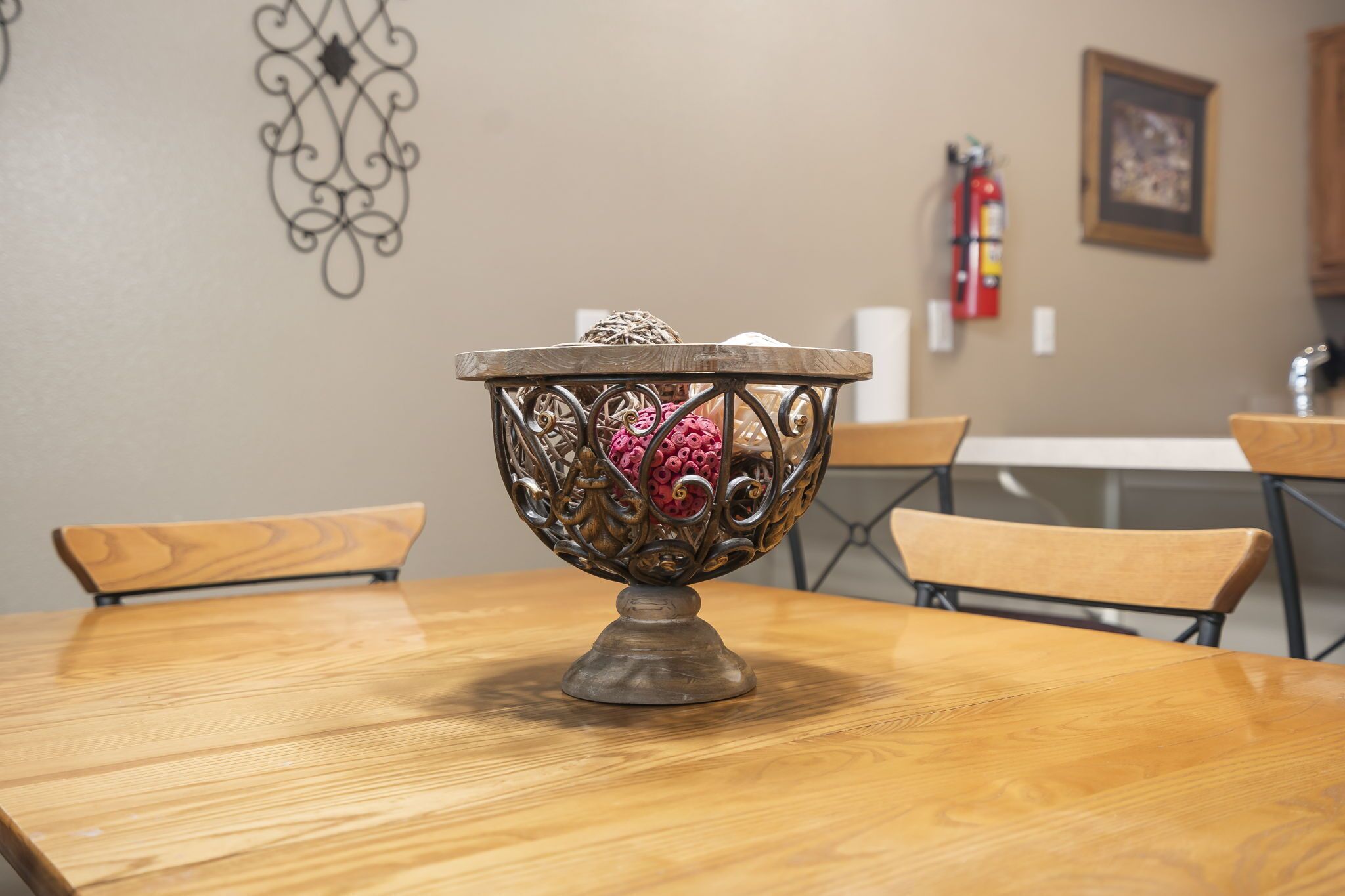 Una mesa de comedor con un cuenco decorativo en el centro, rodeada de sillas.