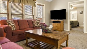 Ein Wohnzimmer mit einer Couch, einem Couchtisch, einem Fernseher und einem Schrank.