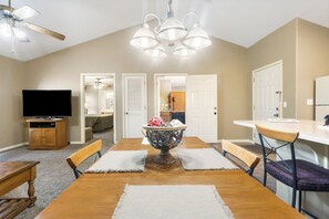 Enjoy a spacious room with a high ceiling, dining table, and comfortable seating for four.