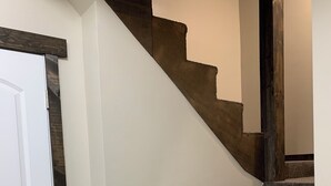 Una escalera con peldaños alfombrados y barandilla de madera.