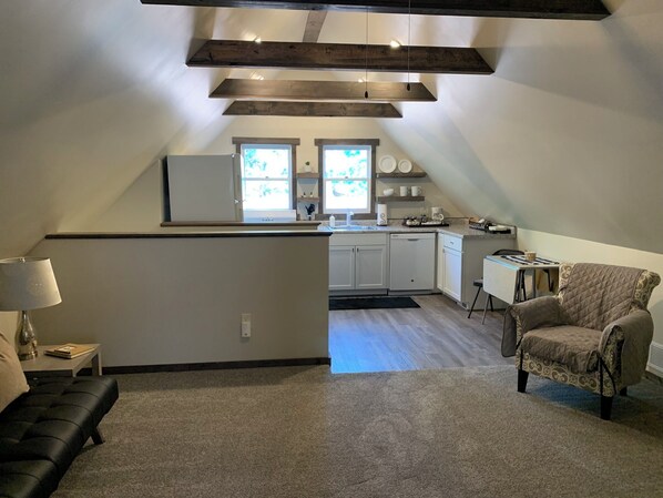Um espaço de estar tipo loft com cozinha, área de refeições e sala de estar.