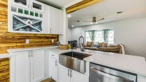 A modern kitchen with white cabinetry, a stainless steel sink, and a built-in dishwasher. - Pet-Friendly Cocoa Beach Home: Walk to Beach! (Cocoa Beach)