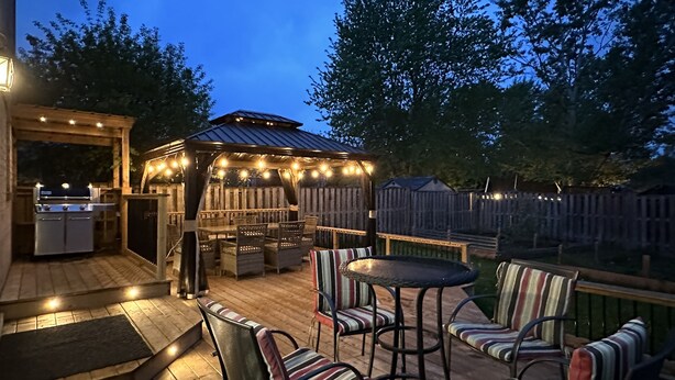 An outdoor patio with a grill, seating area, and string lights. - Soléra — A Light-Filled Minimalist Escape Near Beaches & Golf (Innisfil)