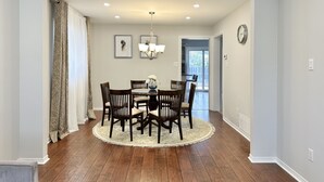 A dining area with a round table, chairs, and a chandelier. - Soléra — A Light-Filled Minimalist Escape Near Beaches & Golf (Innisfil)