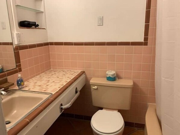 Un baño con inodoro, lavabo y dispensador de toallas.
