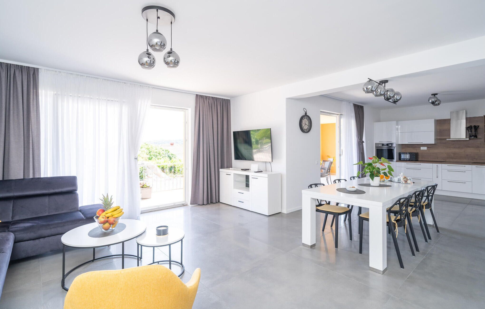 A modern apartment with a living room, dining area, and kitchen.