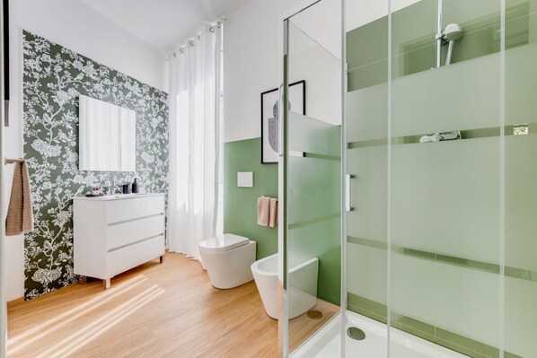 Une salle de bain moderne équipée d’une douche, de toilettes et d’un meuble-lavabo.