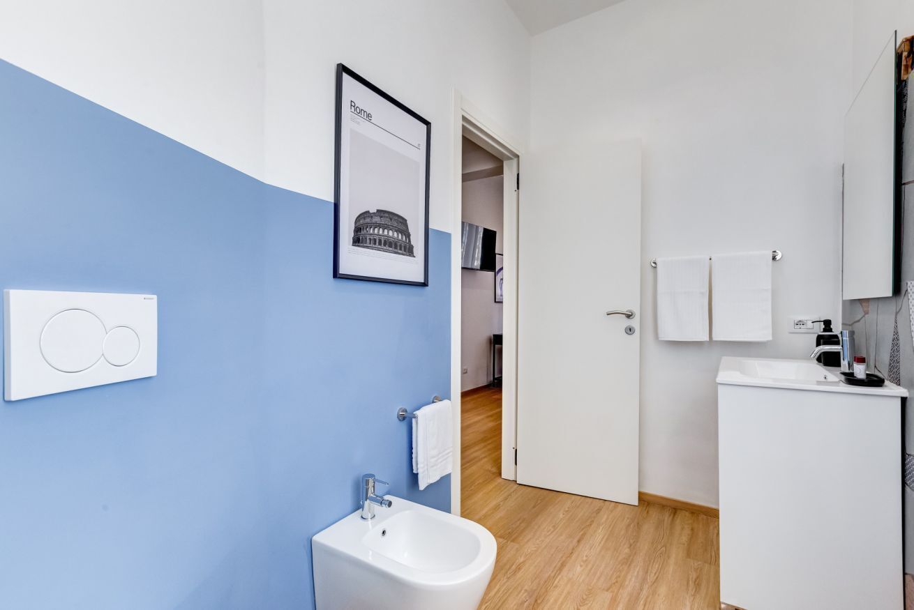 A modern bathroom with a bidet, a sink, and a mirror.