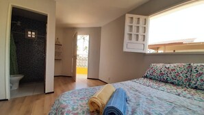 A bedroom with a bed, a window, a shower, and a door leading to a balcony. - Porto de Galinhas Maracaipe, close to the sea. (Ipojuca)