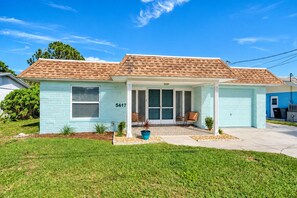 Immerse yourself in the beauty of the house's exterior and its inviting front yard. - Cozy Oasis Screened Pool Picturesque Water Canal Views! (Port Richey)