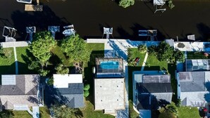 Vista aérea de una zona residencial con casas, piscina y muelle.