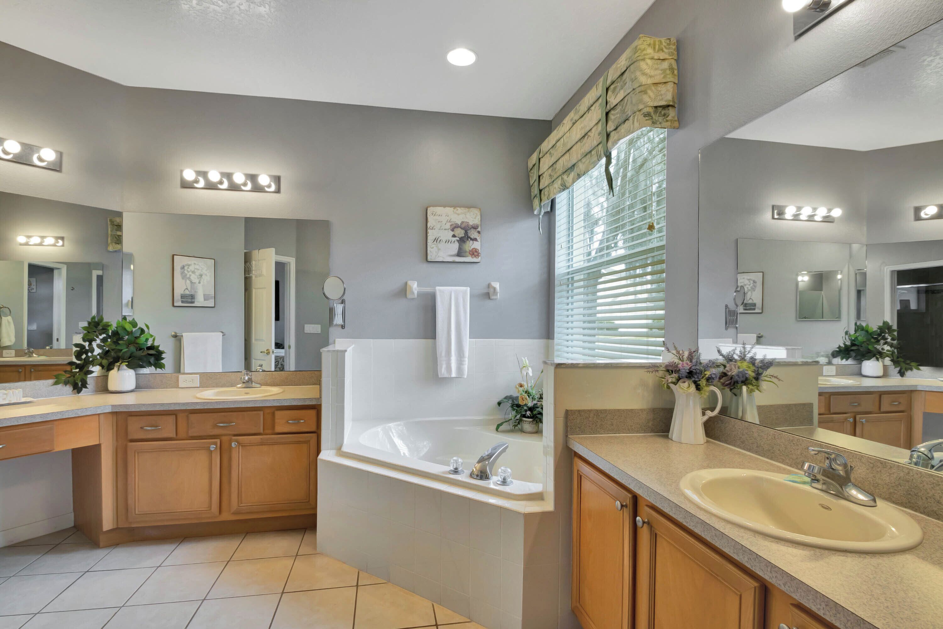 A modern bathroom with a large bathtub, vanity with a sink, and a mirror.