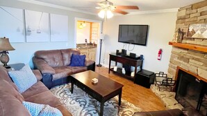 A living room with a fireplace, a television, and a ceiling fan. - Adventure Awaits! Hike, ski, bike, golf & relax! (Beech Mountain)