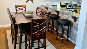 A dining area with a wooden table and chairs, a chandelier, and a star decoration on the wall. - Adventure Awaits! Hike, ski, bike, golf & relax! (Beech Mountain)