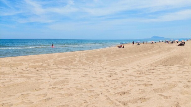 A wide sandy beach with a clear sky and calm sea. - 2 bedroom beach front apartment in Bellreguard (Bellreguard)