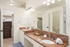 Ein Badezimmer mit zwei Waschbecken, einem großen Spiegel und einem Holzkabinent.