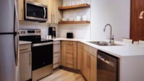 Una cocina equipada con microondas, horno y lavavajillas.