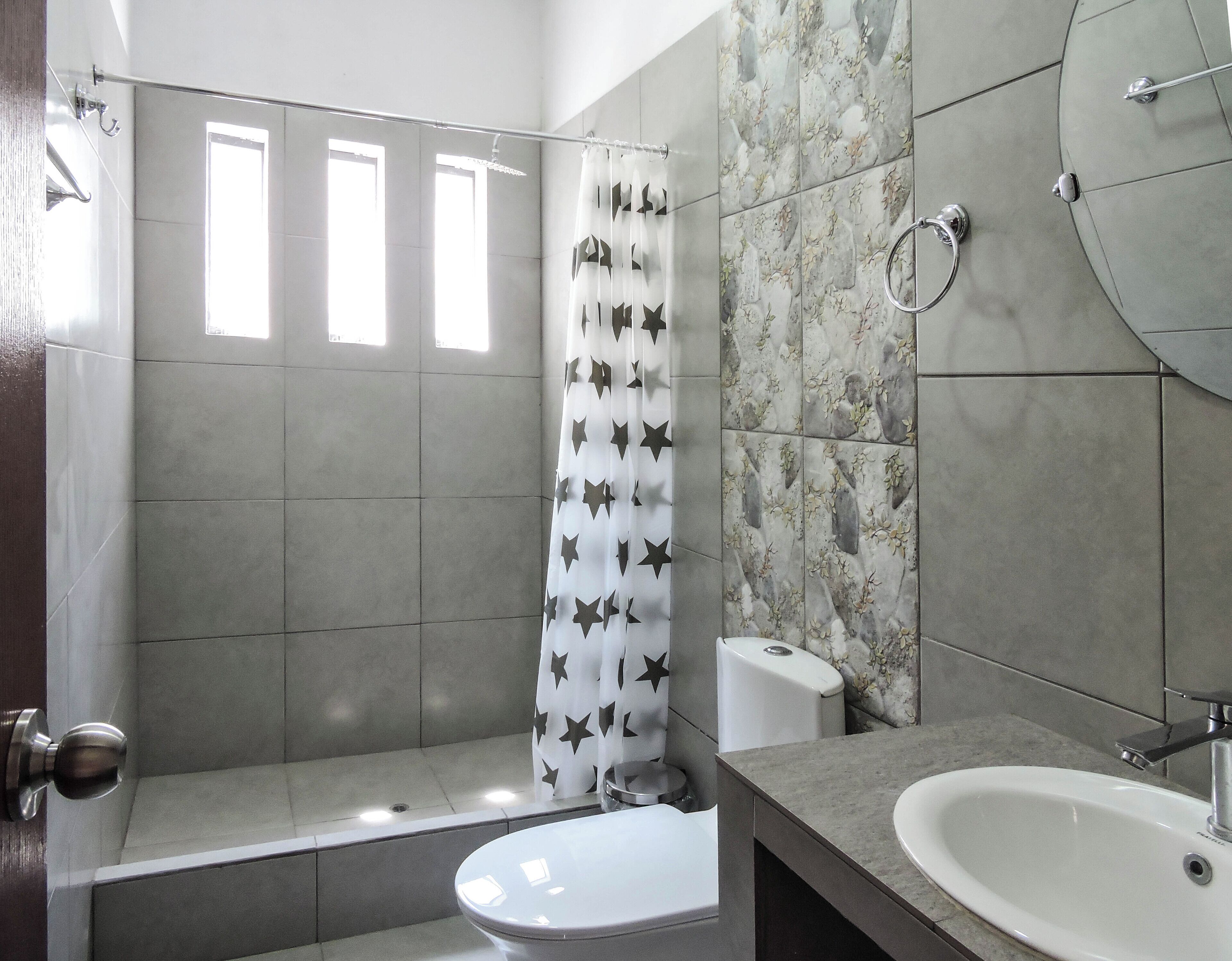 A bathroom with a shower, toilet, and sink.